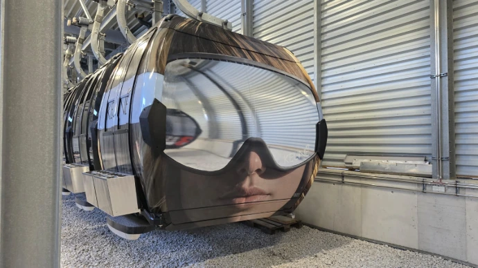 Vollflächig beklebte Seilbahngondel in einer Wartungshalle in Tirol. Die hochwertige Gondelbeklebung wurde mit wetterfester Spezialfolie umgesetzt und zeigt ein detailreiches Motiv mit starker Markenwirkung.